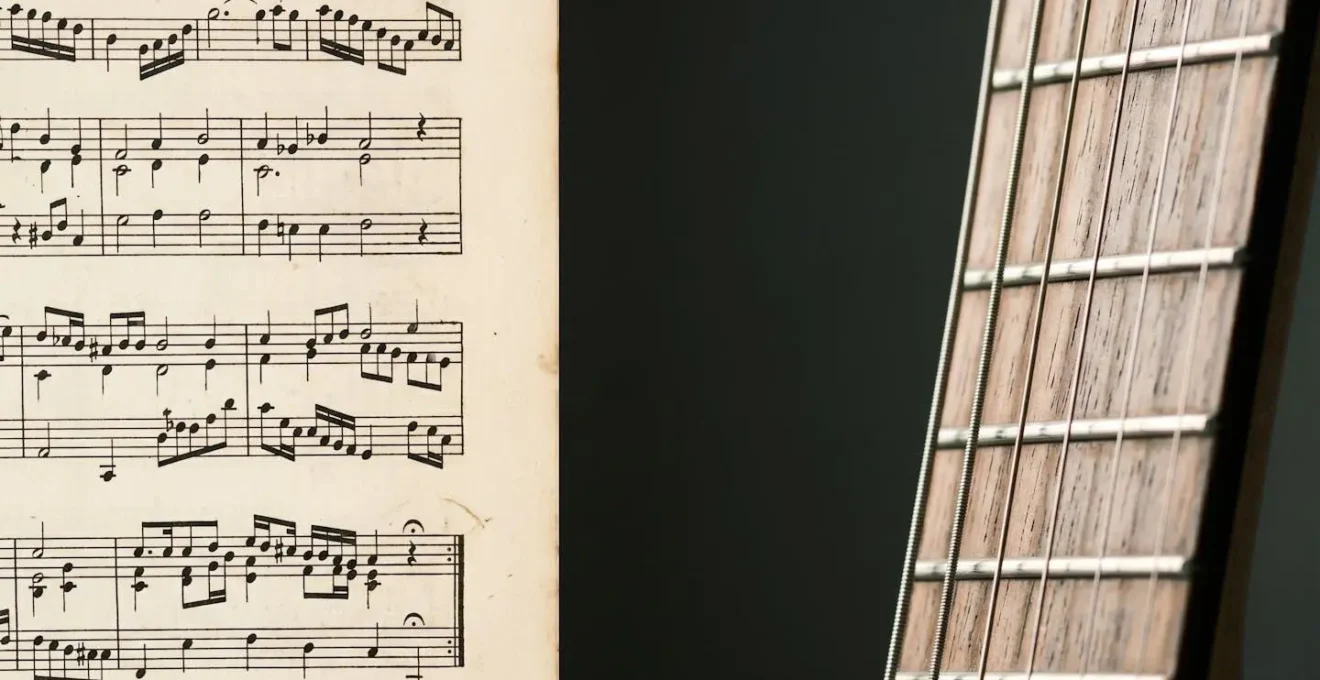 A close-up view showing the intersection of classical sheet music with rock guitar strings in natural studio lighting