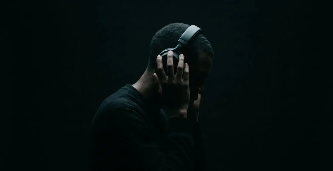 Person experiencing heightened auditory perception in complete darkness with minimal visual cues