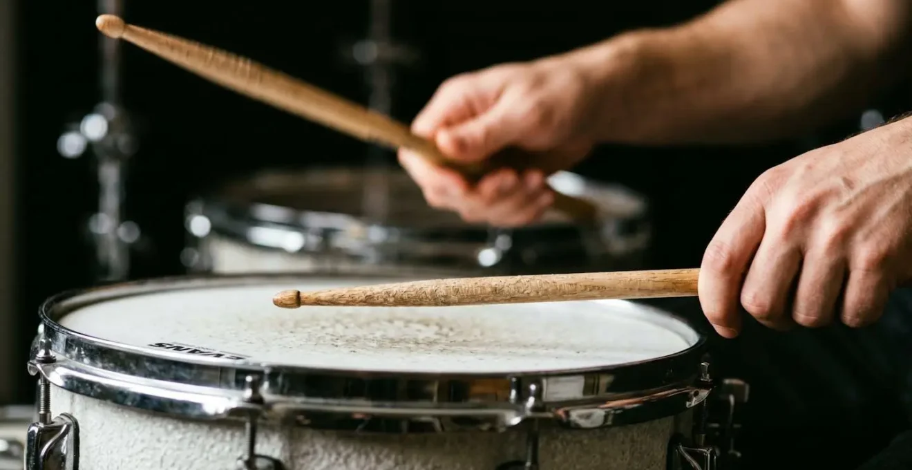 Close-up of drummer's hands showing contrasting stick heights for dynamic control during groove performance