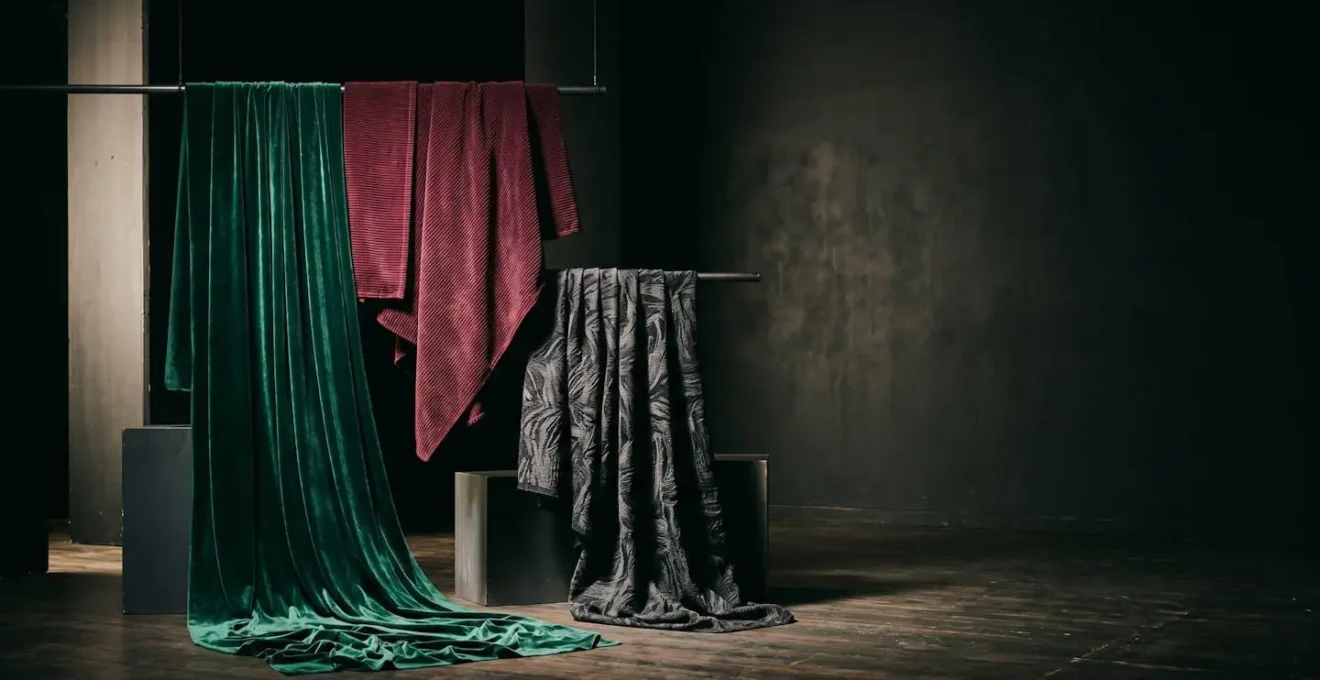 Side-by-side fabric textures showing rich velvet and corduroy against stage lighting with depth and shadow