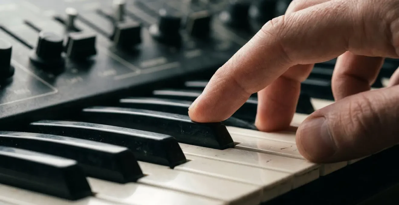 Close-up macro detail of synthesizer keyboard with focus on expressive playing technique