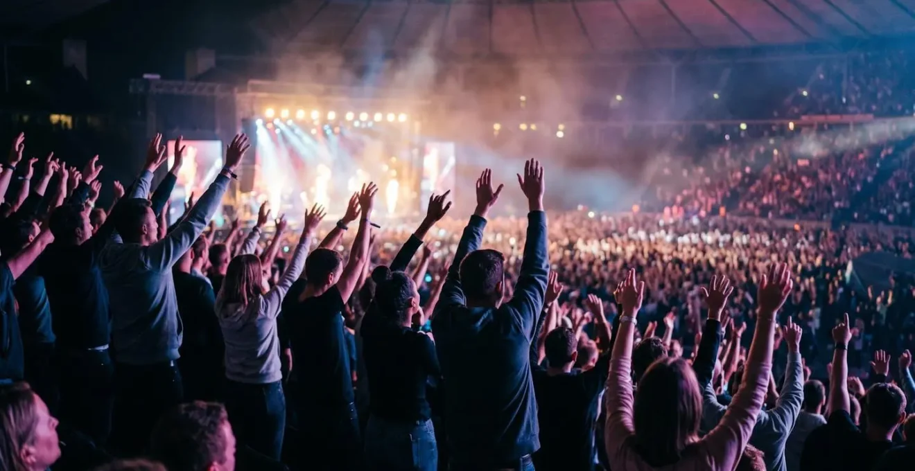 Massive stadium crowd with atmospheric lighting showing collective energy during a rock anthem