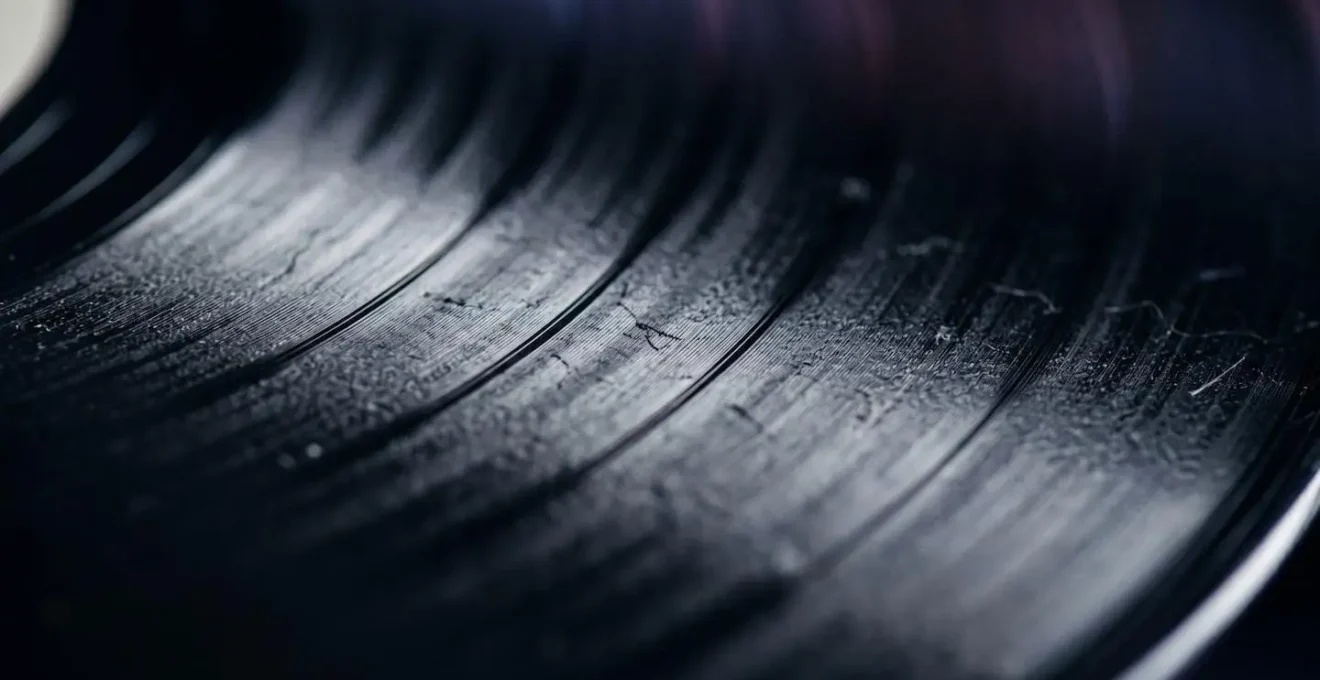 Extreme close-up of a well-worn vinyl record showing grooves and surface wear from repeated play